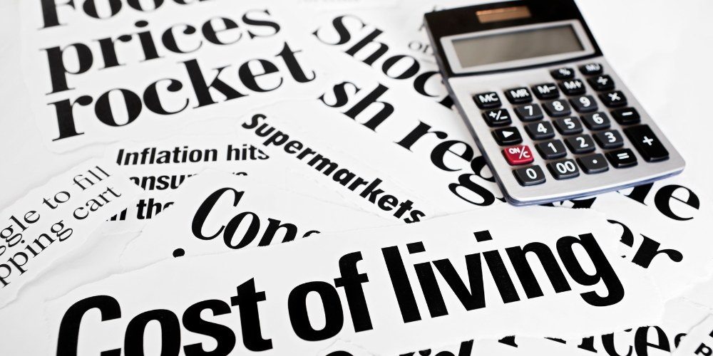 image of newspaper headlines related to the cost of living crisis alongside a calculator